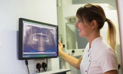 Dental team member looking at all digital x rays