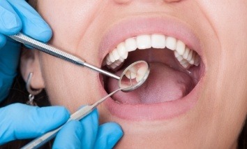 Dentist examining smile after dental crown placement