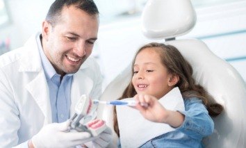 Dentist talking to child during dental checkup