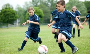 Children playing soccer with athletic mouthguards