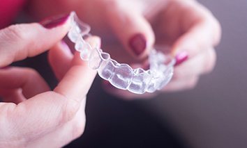 Hand holding an Invisalign aligner