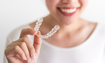 Patient holding her Invisalign aligner