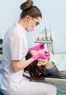 Dental hygienist cleaning woman’s teeth